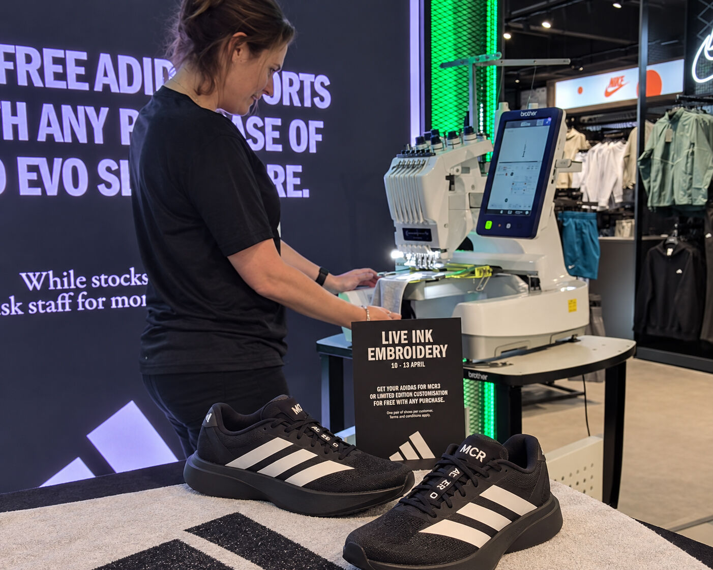 Live Ink live embroidery station inside the adidas store in Manchester, with adidas trainers embroidered with MCR